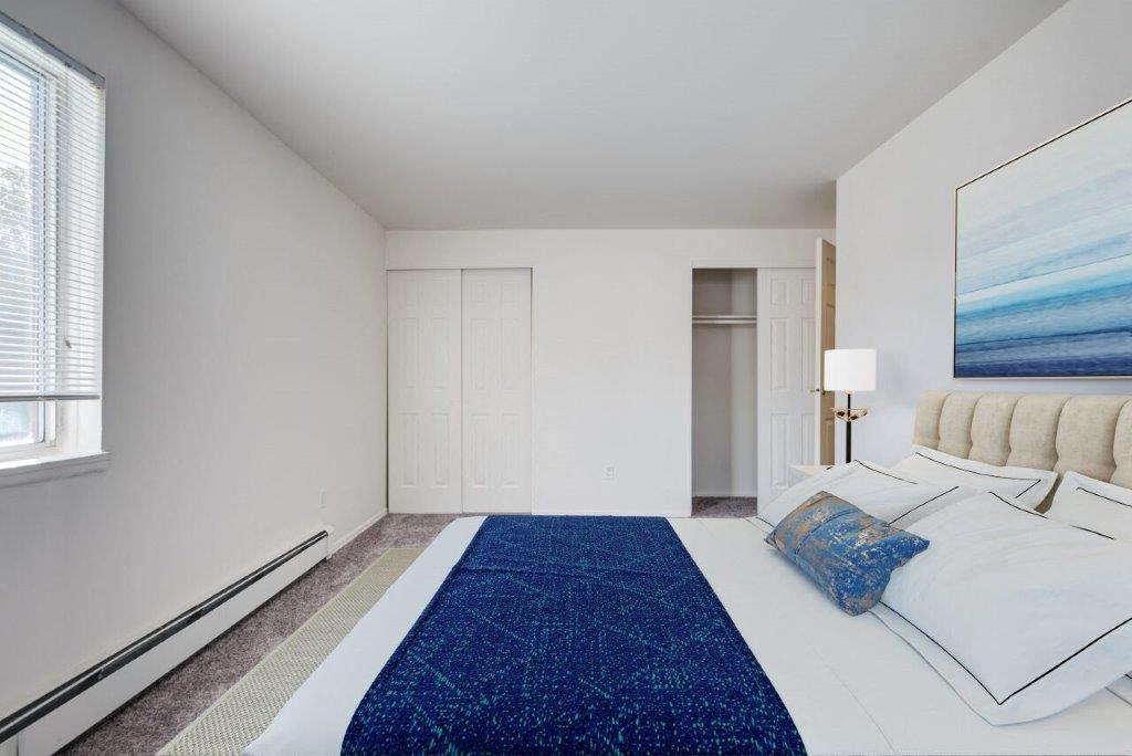staged bedroom with wall to wall carpeting