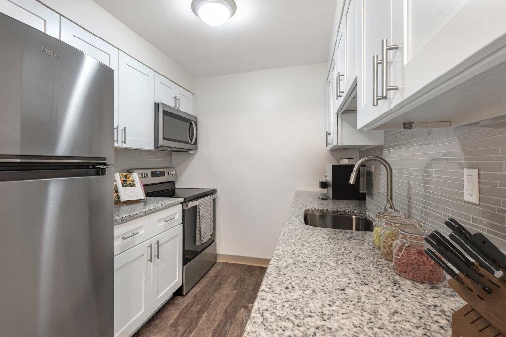 kitchen with white cabinets, granite counters, and stainless appliances