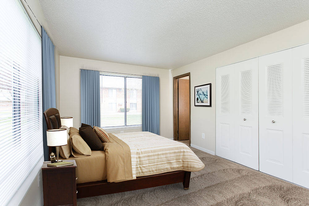 staged bedroom with wall to wall carpeting