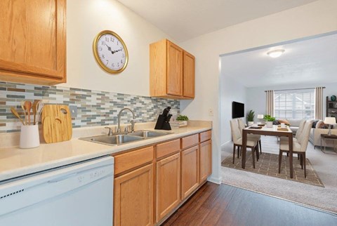 a kitchen with a dishwasher and a clock on the wall