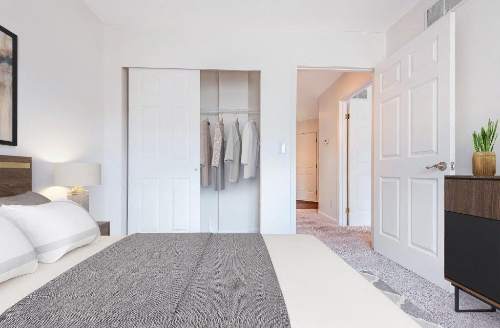 a bedroom with a bed and closet with white doors