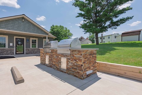 the backyard has an outdoor grill and a patio with a lawn