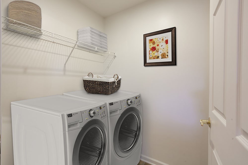 a laundry room with a washing machine and a basket on top of it