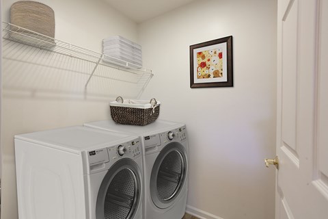a laundry room with a washing machine and a basket on top of it