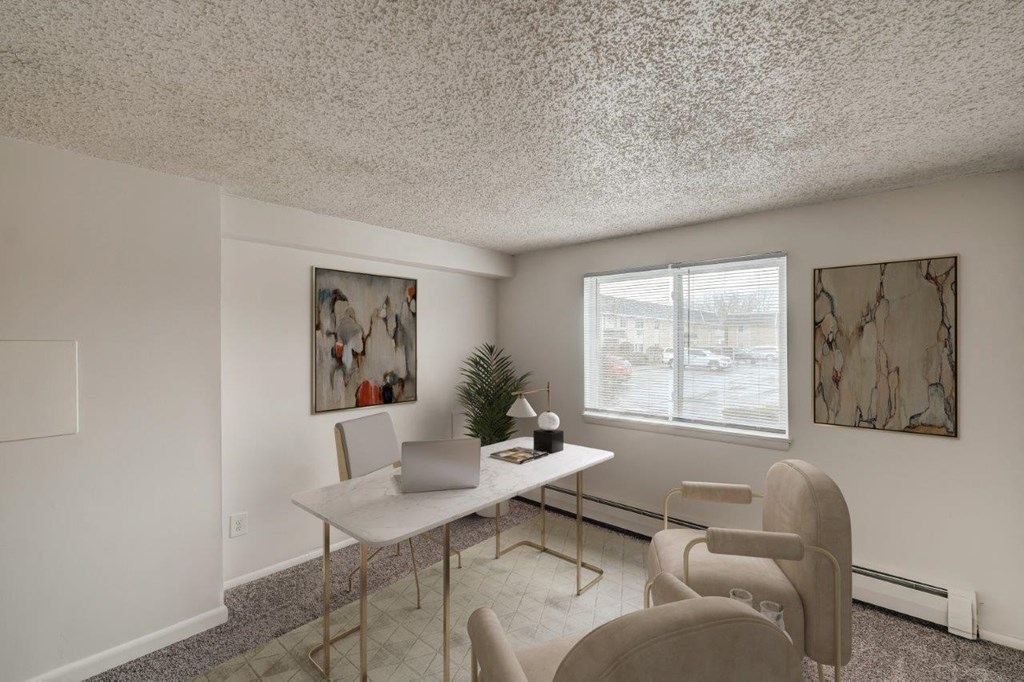 an office with a desk and chairs and a window