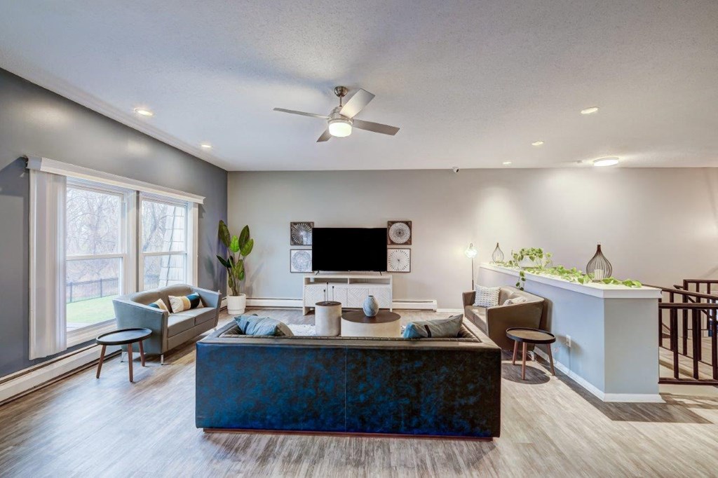 a living room with a blue couch and a ceiling fan