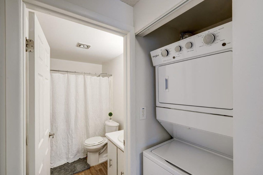 a laundry room with a toilet and a washer and dryer