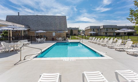 our resort style pool is next to our building with chairs and umbrellas