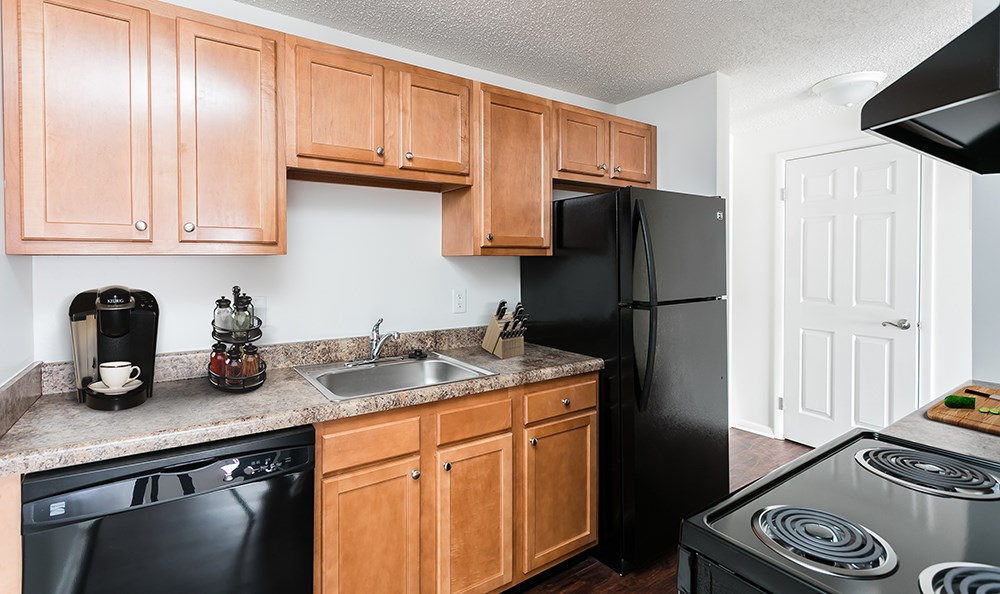 a kitchen with black appliances and wooden cabinets