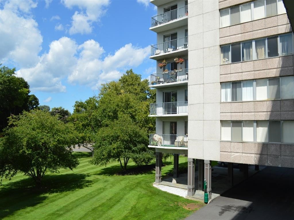 an exterior view of an apartment building with a green lawn
