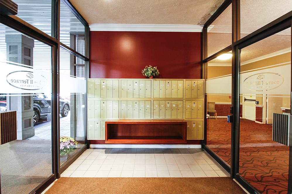 a view of the lobby of a building with a bench and lockers