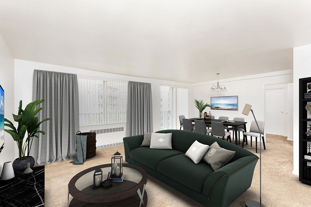 a living room with a green couch and a dining room