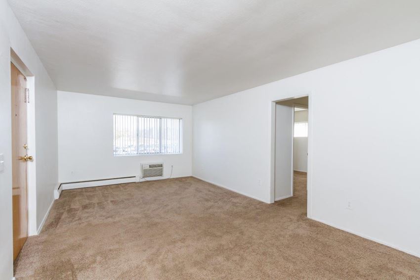 an empty living room with white walls and carpet