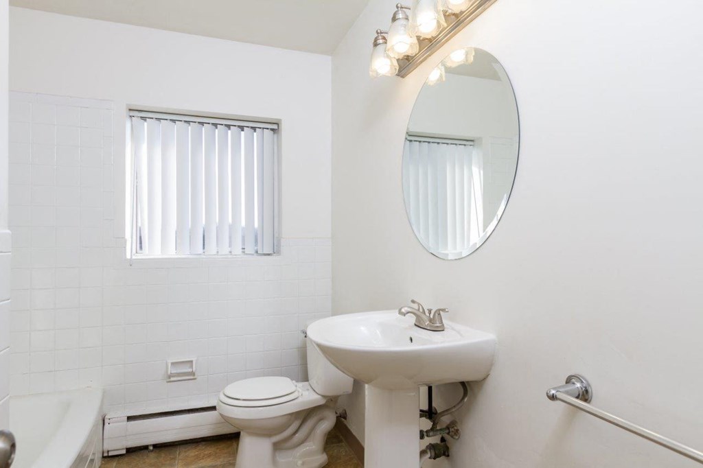 a bathroom with a sink toilet and a mirror