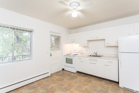A kitchen with white appliances and cabinets.