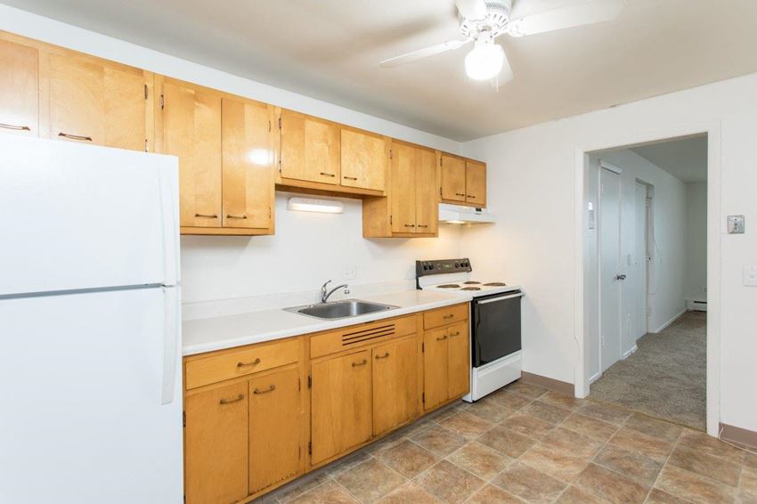 a kitchen with white appliances and wooden cabinets