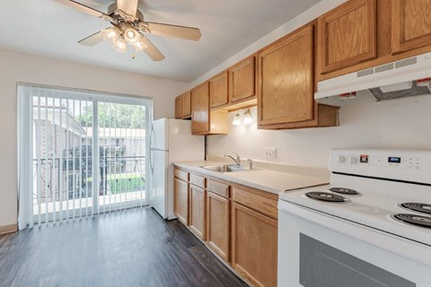 A kitchen with a white stove and wooden cabinets.