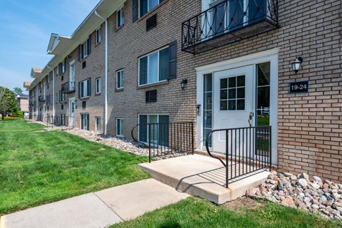 Apartment building number 19-24 has a white door and a black gate.