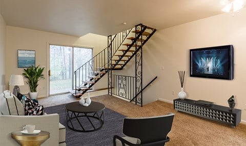 an open living room with a staircase and a tv in the corner