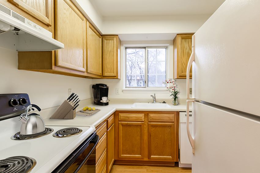 a kitchen with white appliances and wooden cabinets