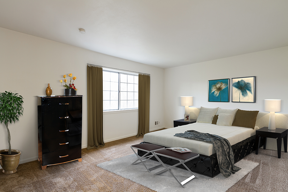 large, staged bedroom with wall to wall carpet