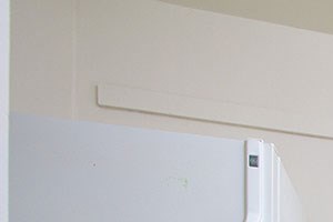 a kitchen with white cabinets and a stove and a refrigerator