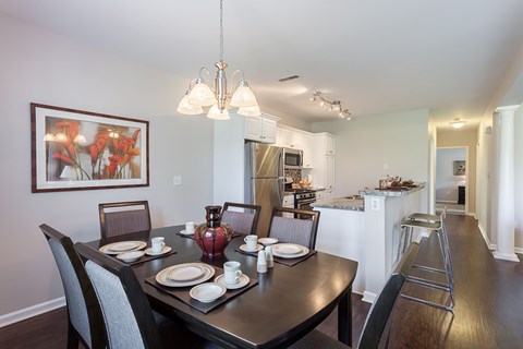 A dining room with a table set for four.