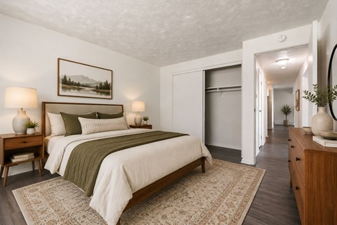 A bedroom with a large bed and a painting on the wall.