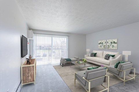 A living room with a couch, chairs, and a television.