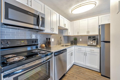A kitchen with white cabinets and stainless steel appliances.