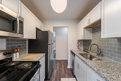 A kitchen with a black stove top oven and a black refrigerator.