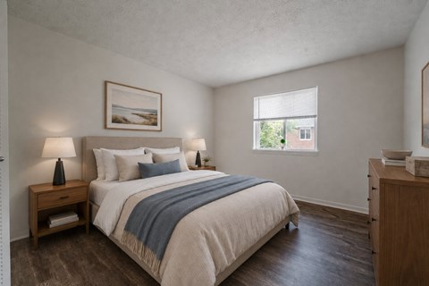 A bedroom with a bed, nightstand, and a painting on the wall.