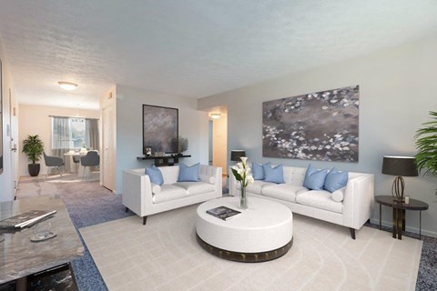 A living room with a white couch, a coffee table, and a painting on the wall.