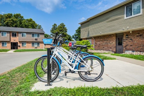 A blue bicycle is parked on a stand outside a building.