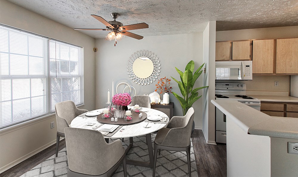 an open kitchen and dining room with a table and chairs and a ceiling fan