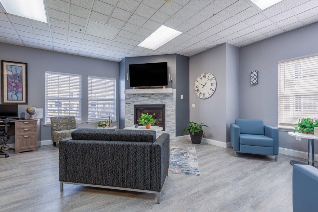 a living room with a fireplace and a clock on the wall