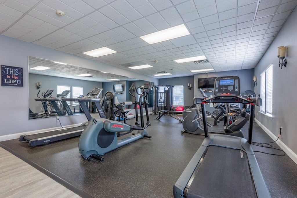 a gym with cardio equipment and weights in a building