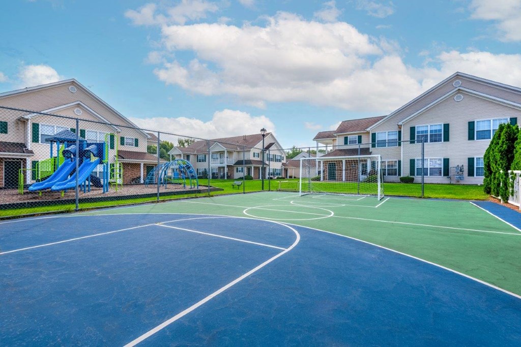 a basketball court with houses in the background