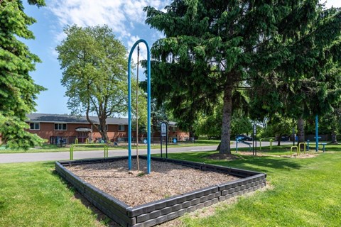 a playground in a park with trees and a swing set
