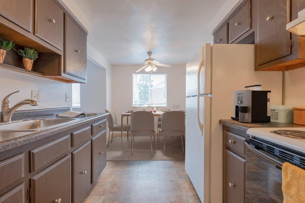 a kitchen with wooden cabinets and a sink and a refrigerator