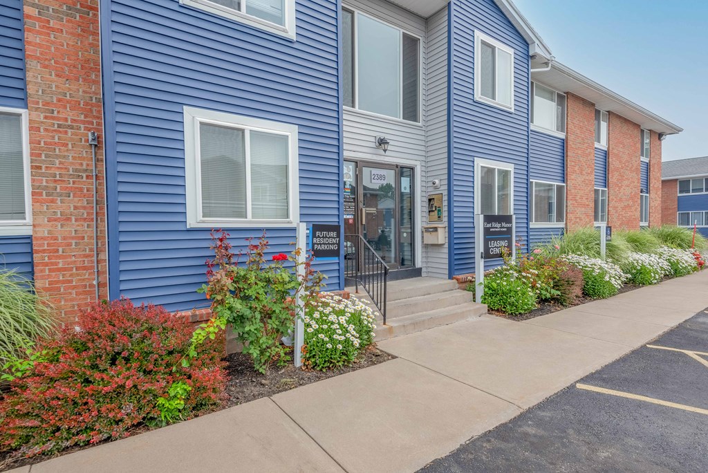 a blue house with a sidewalk in front of it