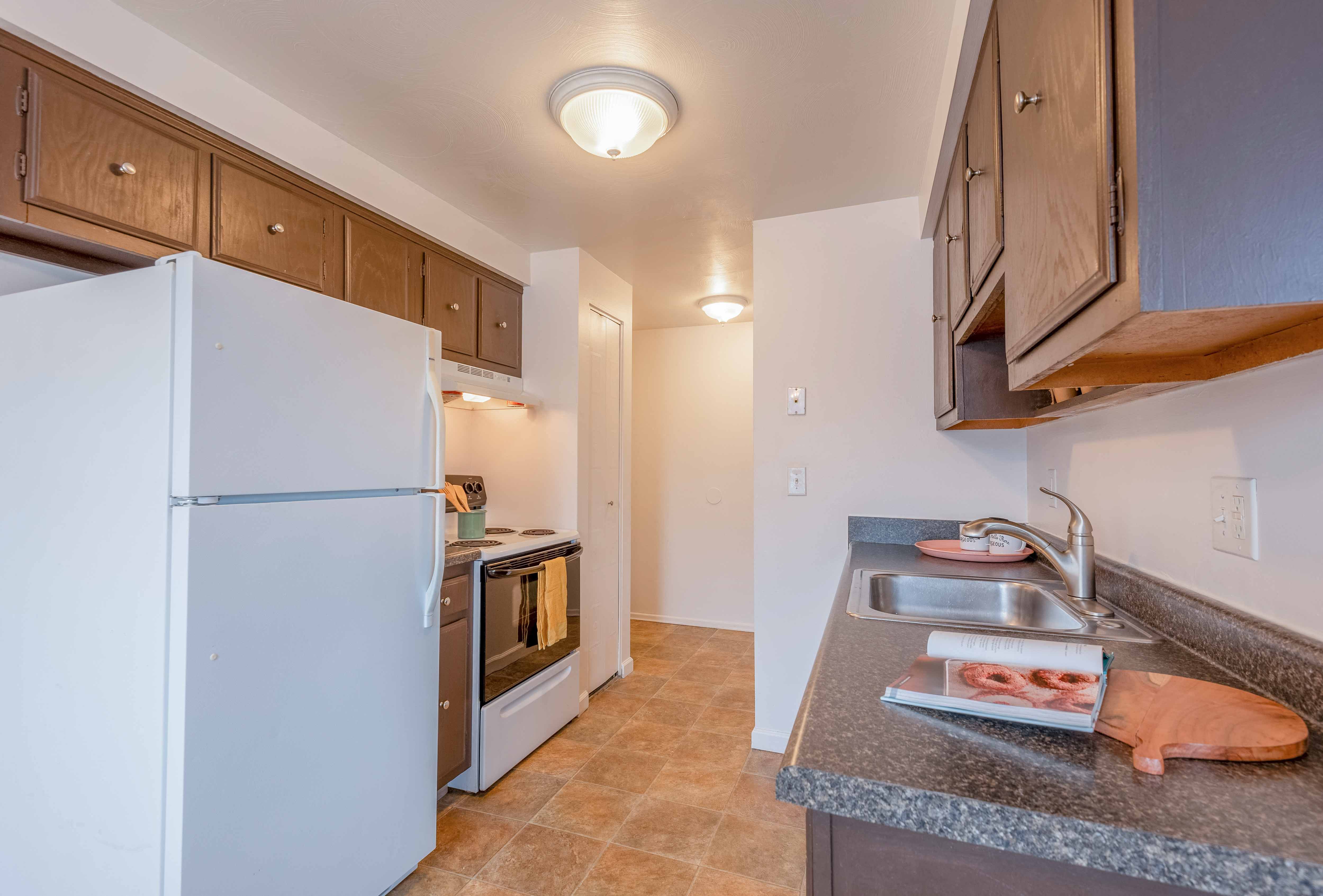 a kitchen with a white refrigerator and a sink