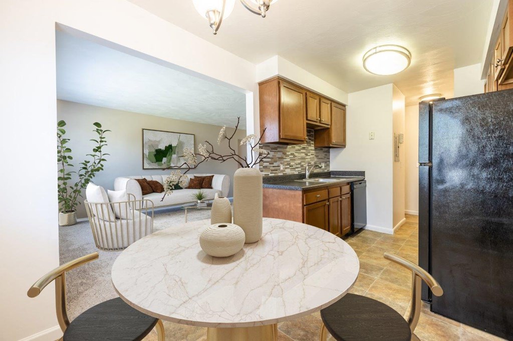a kitchen and living room with a table and a refrigerator