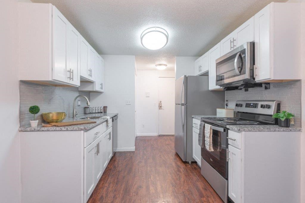 a kitchen with white cabinets and stainless steel appliances