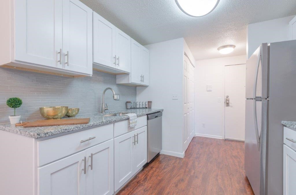 a kitchen with white cabinets and a stainless steel refrigerator