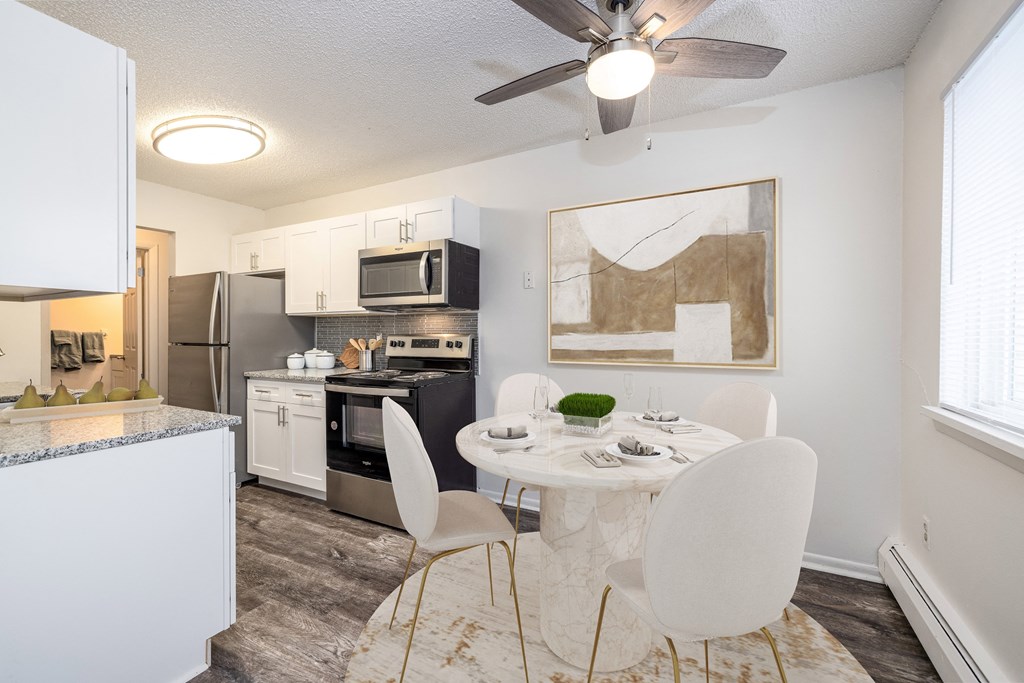 an open kitchen and dining room with a white table and chairs