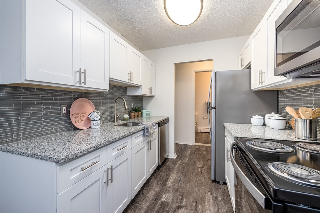 a kitchen with white cabinets and a stainless steel refrigerator