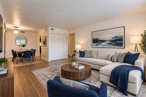 A living room with a white couch and blue chairs.