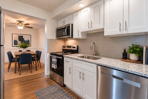 A kitchen with white cabinets and a stainless steel dishwasher.