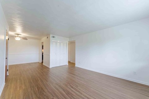 A room with wooden flooring and white walls.